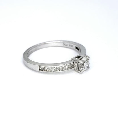 Diamond Solitaire Ring with Princess Cut Diamond Shoulders; central 0.51ct round brilliant-cut diamond, claw set and flanked by 0.43cts channel-set princess-cut diamond shoulders, in 18ct white gold