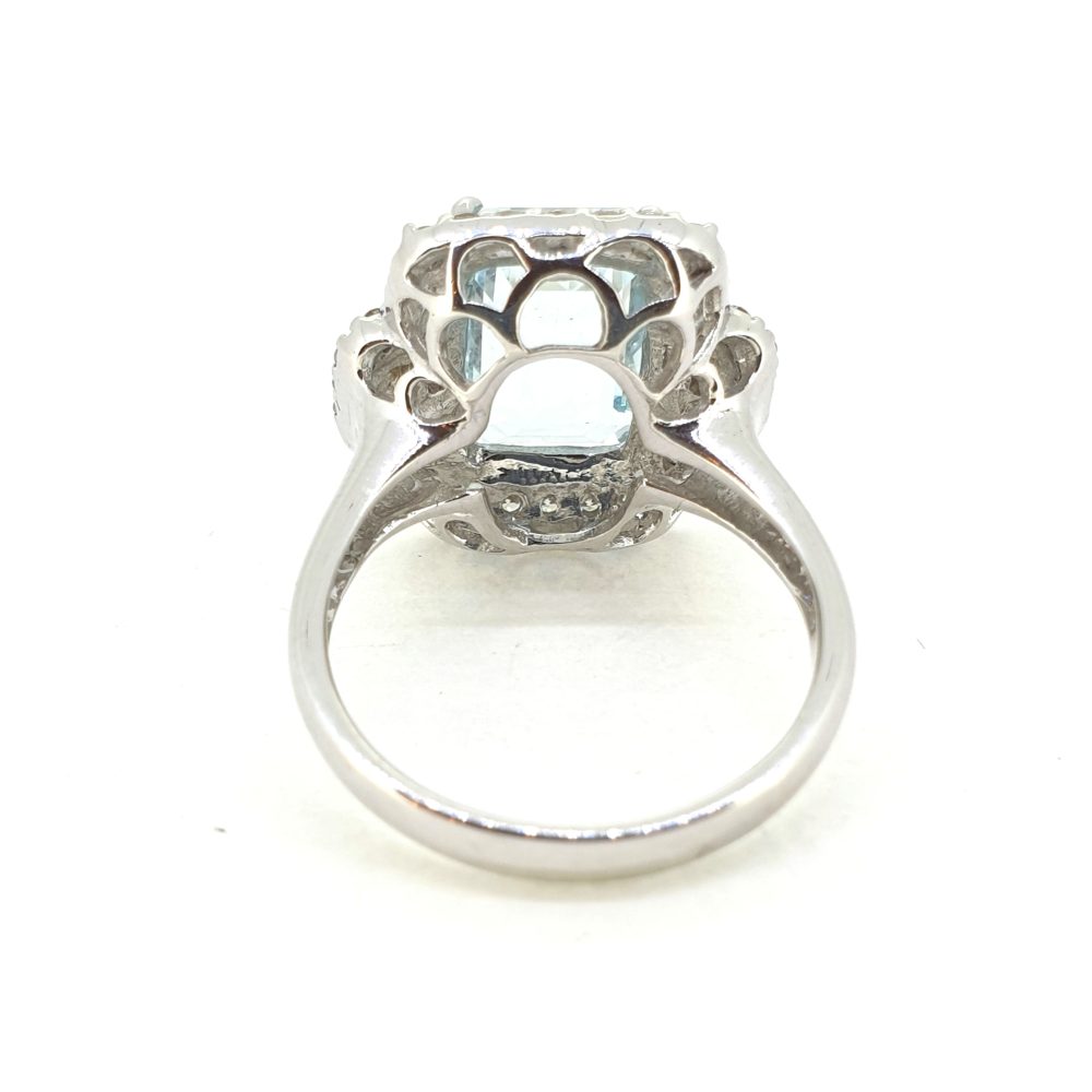 Aquamarine and Diamond Cluster Dress Ring, 3.19ct emerald-shaped aquamarine surrounded by round brilliant-cut diamonds with princess-cut diamonds to the sides in 18ct white gold
