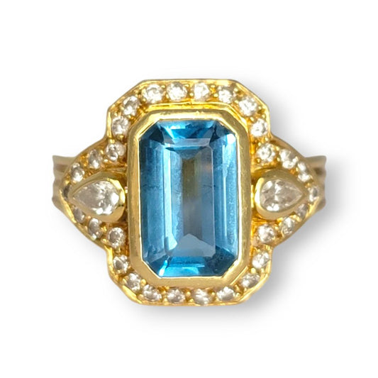 4.4ct Santa Maria Aquamarine and Diamond Cluster Dress Ring, 4.40ct emerald-cut Santa Maria aquamarine flanked by pear-cut diamonds all within diamond border in 18ct yellow gold