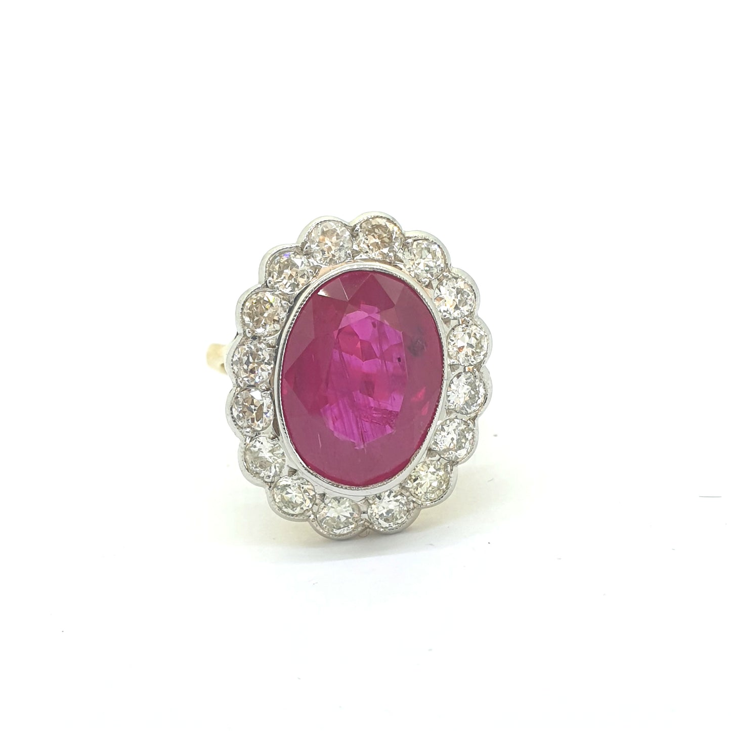 An oval ruby and round diamond scalloped edge cluster ring in yellow and white gold