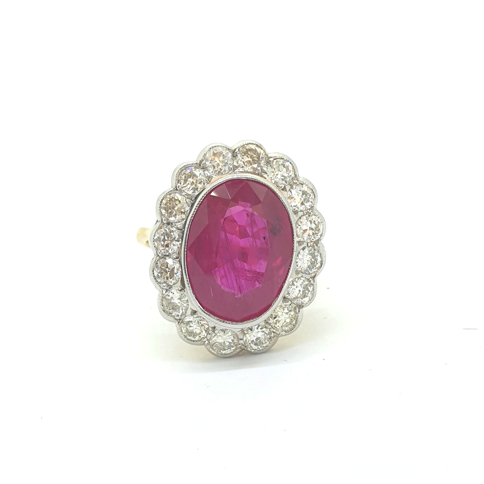 An oval ruby and round diamond scalloped edge cluster ring in yellow and white gold