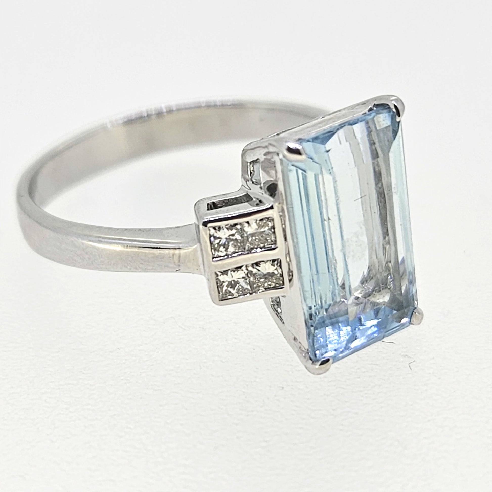 An emerald cut aquamarine and diamond ring in white gold