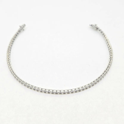 A brilliant cut diamond line bracelet, clasp open, on a white background