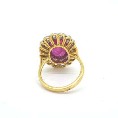 An oval ruby and round diamond scalloped edge cluster ring in yellow and white gold