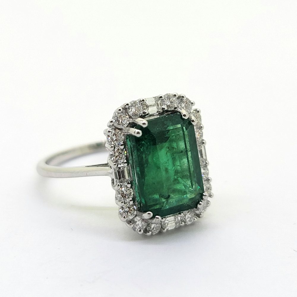 5.24ct Emerald and Diamond Cluster Ring, emerald-cut emerald surrounded by 0.88cts brilliant-cut diamonds accented with a baguette-cut diamond to each side