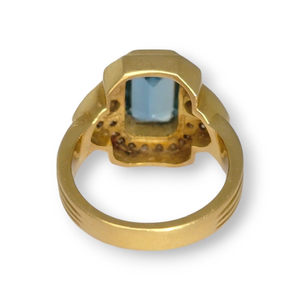 4.4ct Santa Maria Aquamarine and Diamond Cluster Dress Ring, 4.40ct emerald-cut Santa Maria aquamarine flanked by pear-cut diamonds all within diamond border in 18ct yellow gold