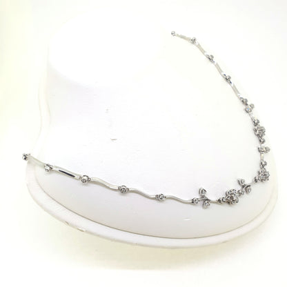 A floral diamond necklace in 14ct white gold, on a neck bust, on a white background