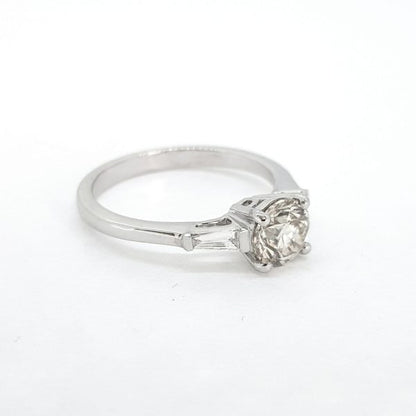 1.09ct Diamond Solitaire Engagement Ring with Baguette Shoulders; classic single stone 1.09 carat round brilliant-cut diamond, claw-set and flanked by tapered baguette-cut diamonds to the shoulders, in 18ct white gold