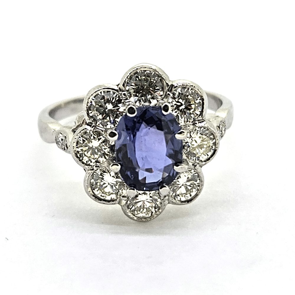 1.60ct Sapphire and Diamond Floral Cluster Engagement Ring in Platinum, 1.60ct oval blue sapphire surrounded by 1.40cts brilliant-cut diamonds in timeless flower cluster design