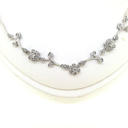 A floral diamond necklace in 14ct white gold, on a neck bust, on a white background