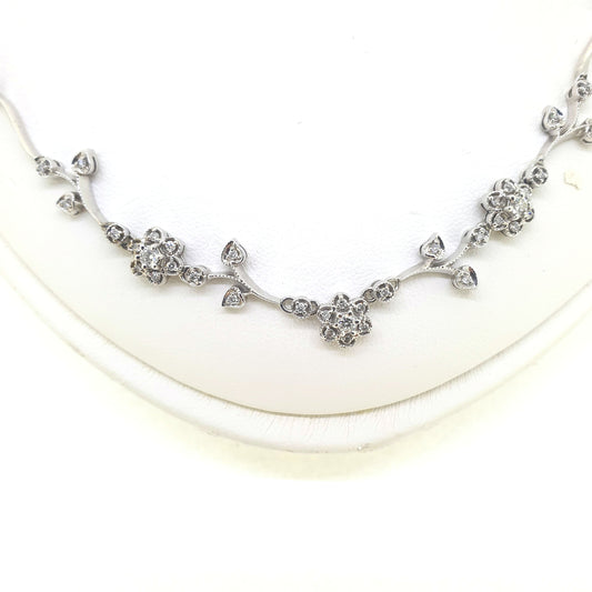 A floral diamond necklace in 14ct white gold, on a neck bust, on a white background