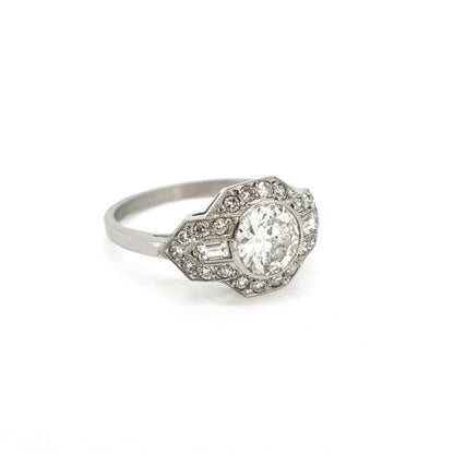 Art Deco Style Diamond Cluster Ring; 0.92 carat diamond has a geometric diamond-set surround accented with baguette cut diamond shoulders, in 18ct white gold