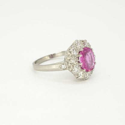 Edwardian Style Pink Sapphire and Diamond Cluster Ring in Platinum; 1.40ct oval pink sapphire surrounded by ten sparkling brilliant-cut diamonds, 1.00 carat diamonds