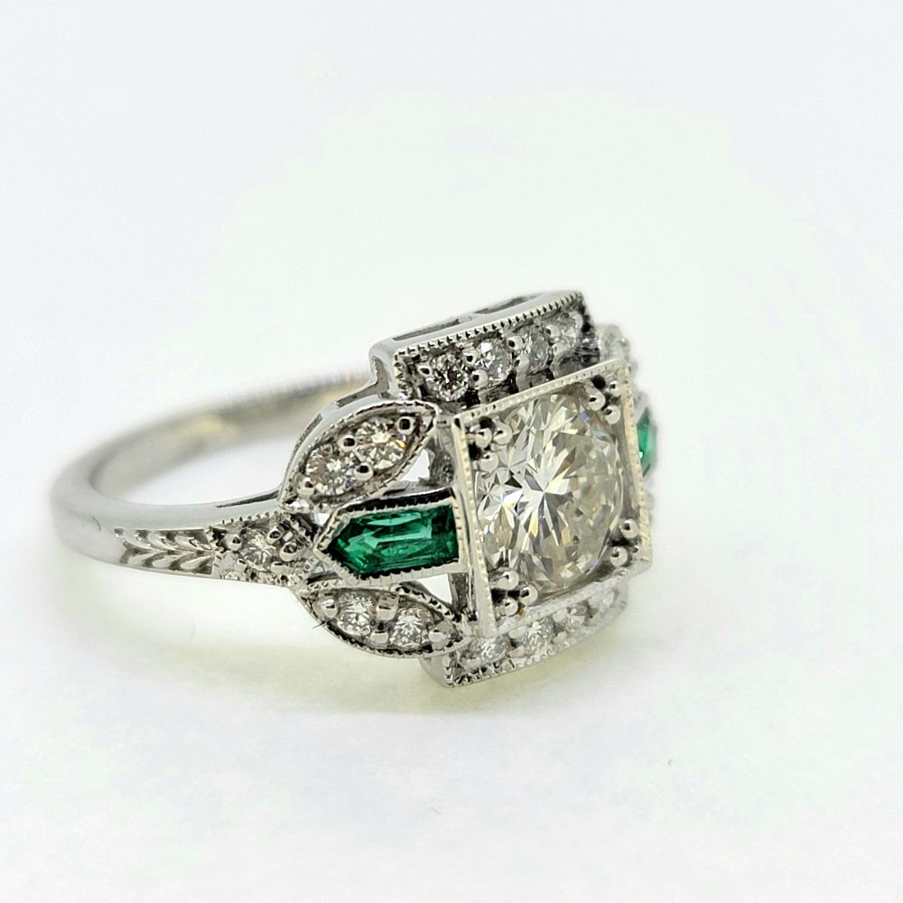 Vintage 0.96ct Diamond and Emerald Cluster Engagement Ring, 0.96ct diamond flanked top and bottom by diamond border in 18ct white gold with emerald and diamond fleur-de-lis shoulders