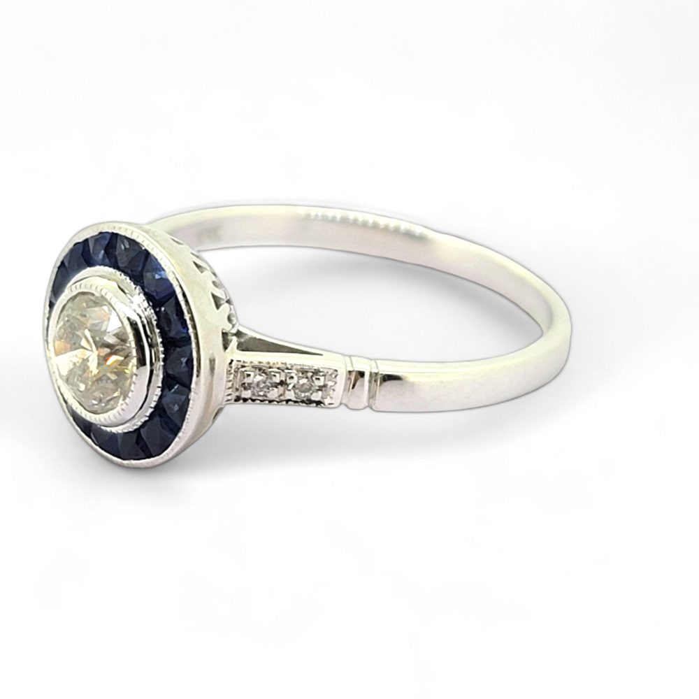 0.53ct Diamond and Sapphire Target Engagement Ring, 0.53ct round brilliant-cut diamonds surrounded by a halo of calibre sapphires in 18ct white gold