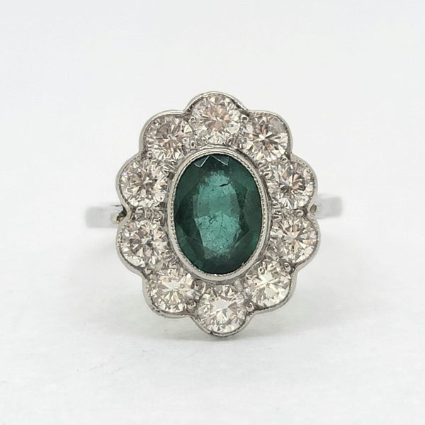 Modern Emerald and Diamond Floral Cluster Ring in Platinum, central 1.30ct oval emerald surrounded by 1.35cts sparkling diamonds rubover set in platinum