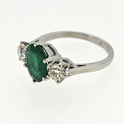 A three stone oval emerald and round diamond ring in platinum