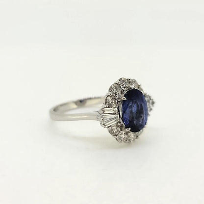 An oval sapphire, brilliant cut and baguette cut diamond cluster ring in white gold