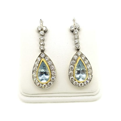 Aquamarine and Diamond Cluster Drop Earrings; featuring 4cts pear aquamarines with yellow gold borders and surrounded by diamonds, suspended from diamond-set drops, in 18ct white gold