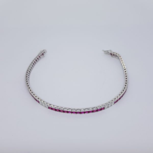 Princess Cut Ruby and Diamond Line Bracelet; 8.13cts princess-cut rubies accented with 1.05cts princess-cut diamond set sections, in 18ct white gold