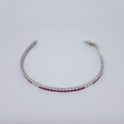 Princess Cut Ruby and Diamond Line Bracelet; 8.13cts princess-cut rubies accented with 1.05cts princess-cut diamond set sections, in 18ct white gold