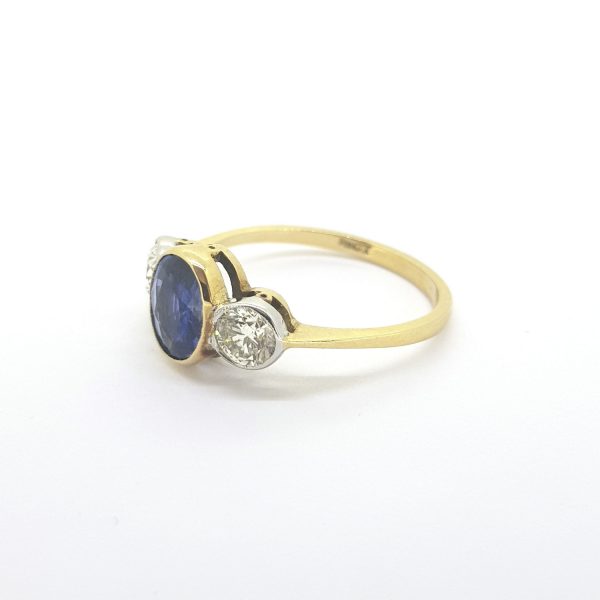 Sapphire and Diamond Three Stone Ring; featuring a 1.26 carat oval faceted sapphire flanked by 0.67cts brilliant cut diamonds, in 18ct yellow gold