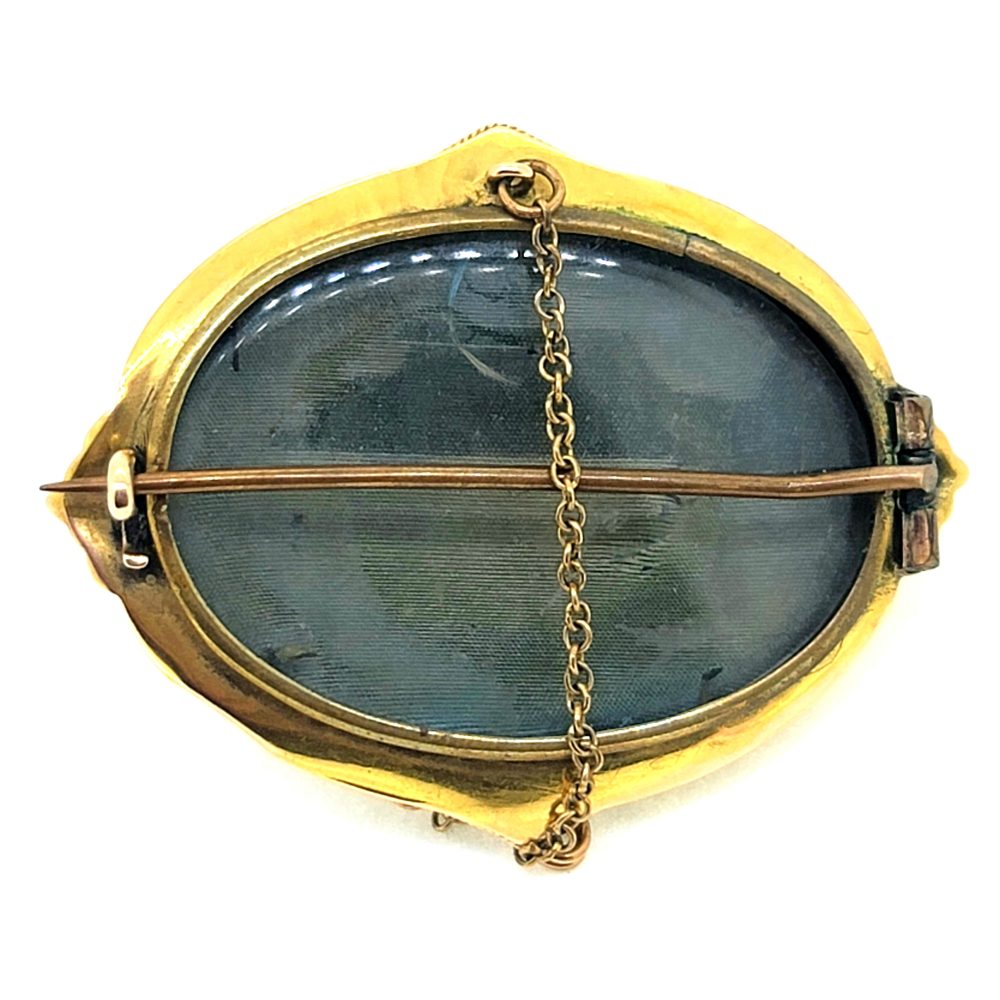 Antique Cabochon Garnet and Gold Locket Brooch, decorative 18ct yellow gold brooch with ball and ropework detailing with central oval cabochon garnet surrounded by white enamel. With locket compartment to reverse