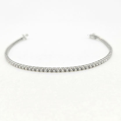 A brilliant cut diamond line bracelet, clasp open, on a white background