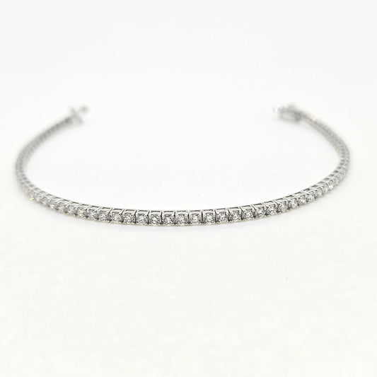 A brilliant cut diamond line bracelet, clasp open, on a white background