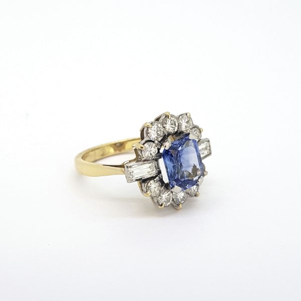Vintage Sapphire and Diamond Floral Cluster Ring; 2.20 carat octagonal-cut sapphire within a 1.80ct brilliant and baguette-cut diamond surround, in 18ct gold