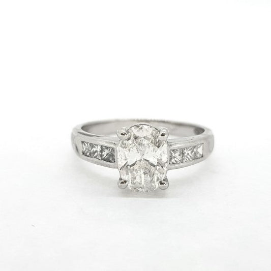 Oval Cut Diamond Engagement Ring with Princess Cut Diamond Shoulders; central 1.22ct oval cut diamond, claw set and flanked by 0.36cts channel set square princess-cut diamonds, in 18ct white gold