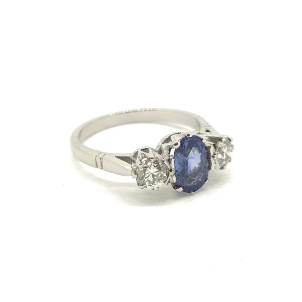 Sapphire and Diamond Three Stone Ring in Platinum; central 1.10ct oval sapphire flanked by 0.65cts diamonds, all claw-set and mounted in platinum
