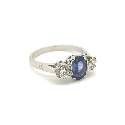 Sapphire and Diamond Three Stone Ring in Platinum; central 1.10ct oval sapphire flanked by 0.65cts diamonds, all claw-set and mounted in platinum