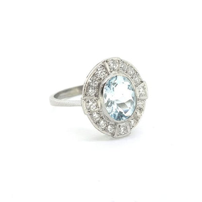 Aquamarine and Diamond Oval Cluster Ring in Platinum; 1.50ct oval faceted mixed cut Aquamarine surrounded by brilliant-cut diamonds in a compass style surround, with four diamonds slightly raised at 90 degree focal points