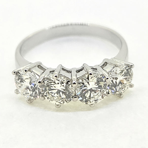 A four stone brilliant cut diamond ring in white gold, on a white background