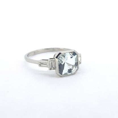 Aquamarine and Baguette Diamond Dress Ring; central octagonal-cut aquamarine decorated with baguette cut diamonds to the shoulders, in 18ct white gold