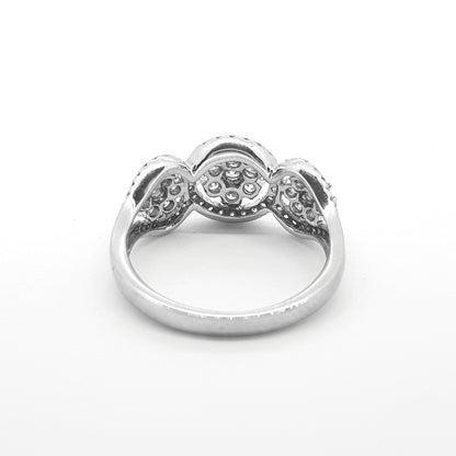 A circular triple cluster ring with round diamonds in white gold, against a white background
