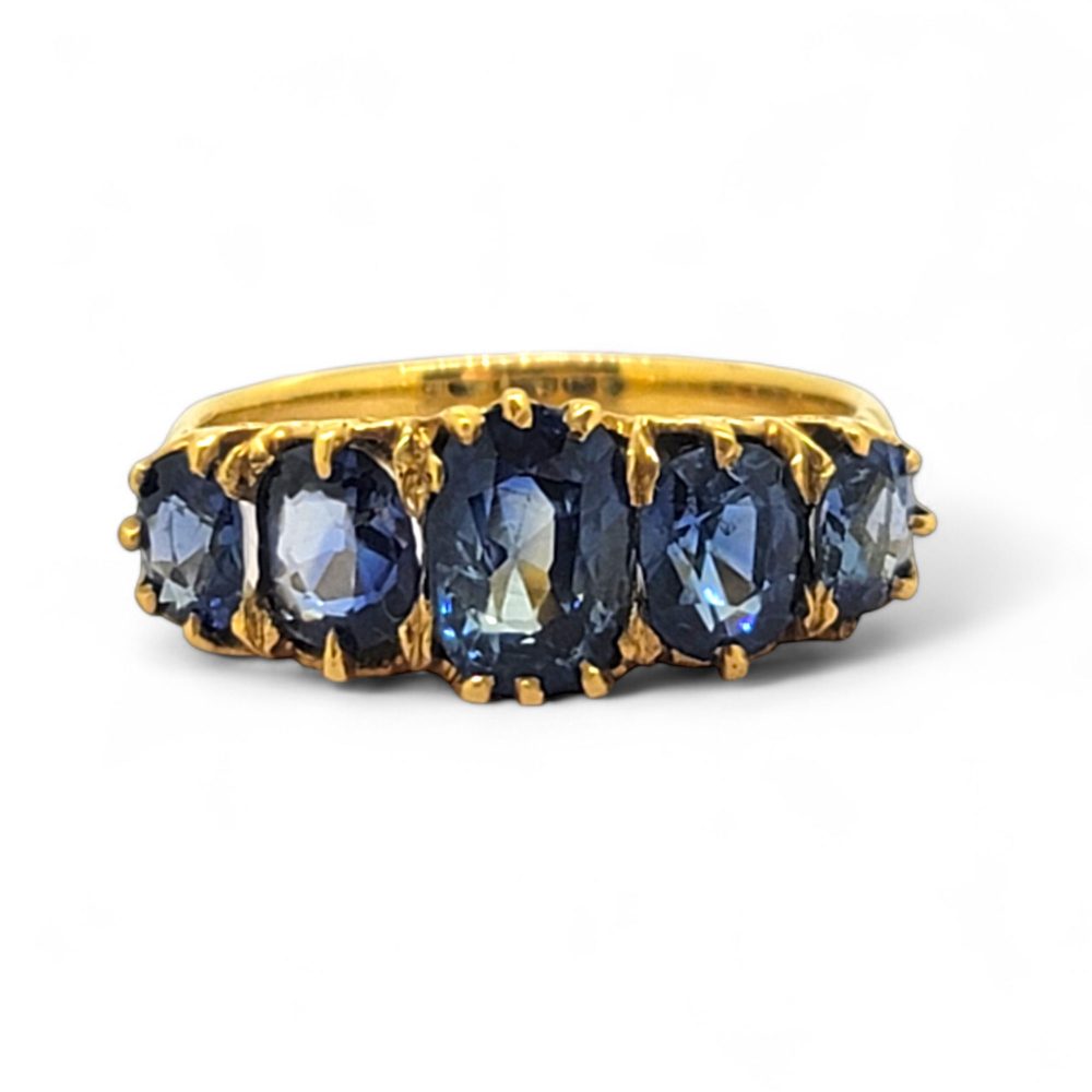 Antique Style Natural Sapphire Five Stone Ring, composed of five graduated oval blue sapphire claw set and mounted in 18ct yellow gold