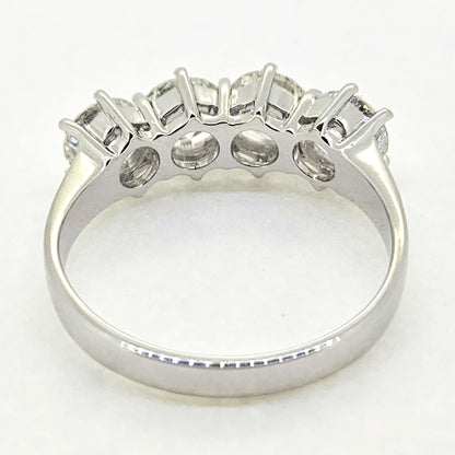 A four stone brilliant cut diamond ring in white gold, viewed from behind, on a white background