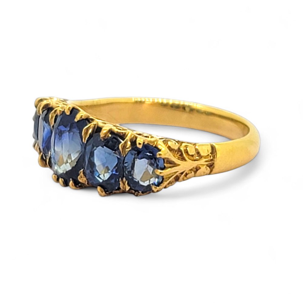 Antique Style Natural Sapphire Five Stone Ring, composed of five graduated oval blue sapphire claw set and mounted in 18ct yellow gold
