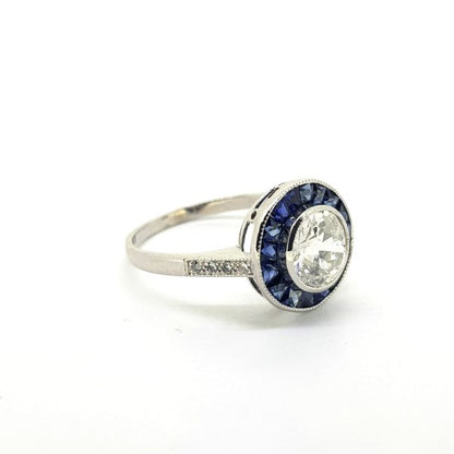 Sapphire and Diamond Cluster Target Ring; central 1.19ct brilliant-cut diamond set within a calibre-cut sapphire border, in 18ct white gold