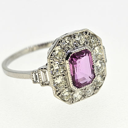 An emerald cut pink sapphire and diamond cluster ring in platinum