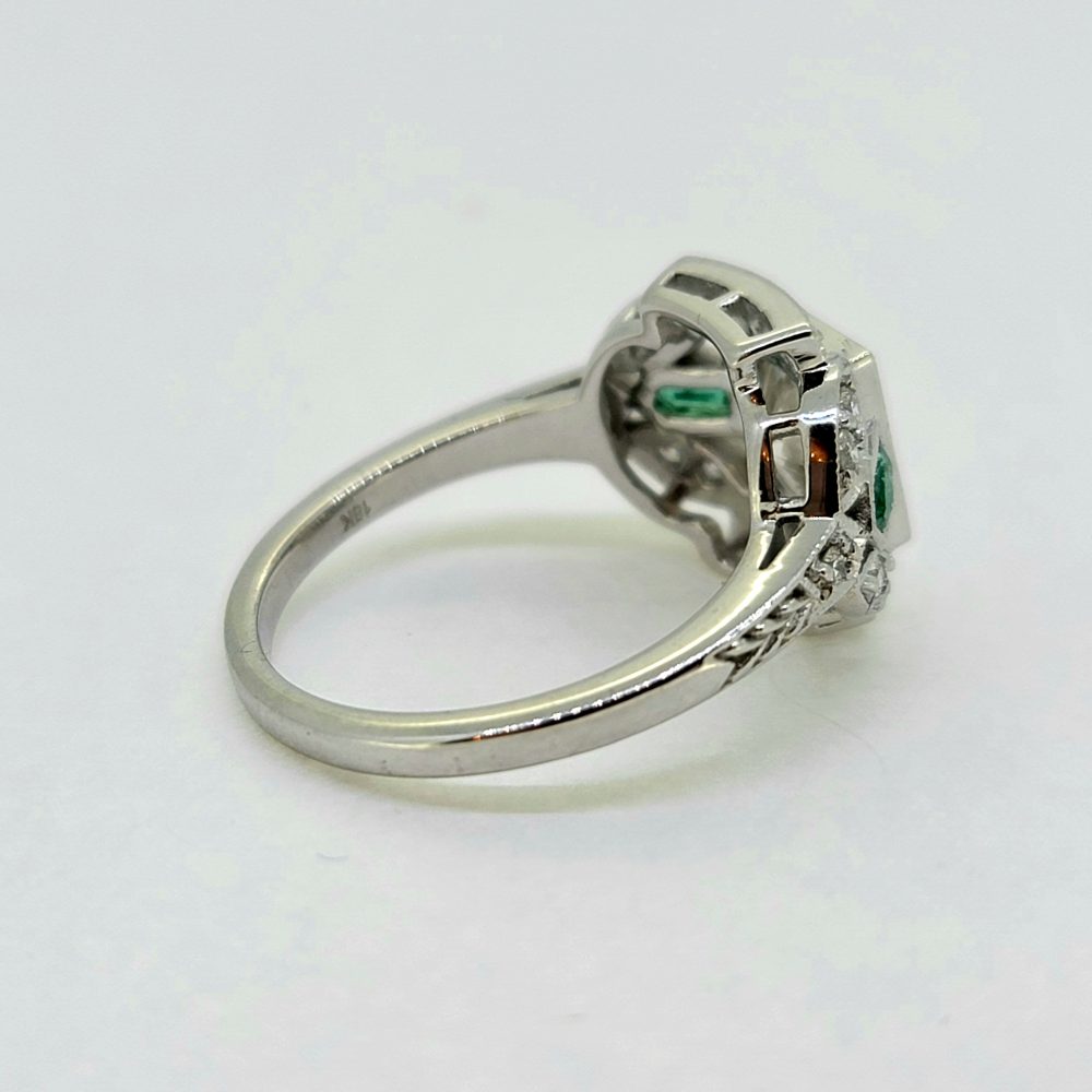 Vintage 0.96ct Diamond and Emerald Cluster Engagement Ring, 0.96ct diamond flanked top and bottom by diamond border in 18ct white gold with emerald and diamond fleur-de-lis shoulders