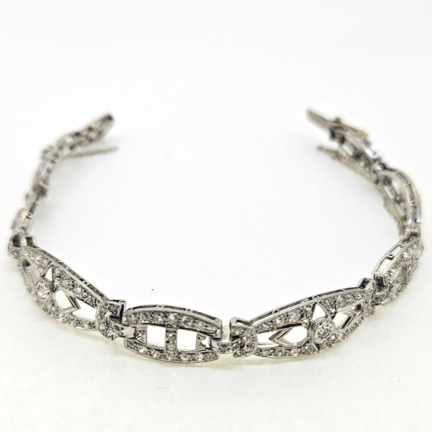 An Art Deco diamond link bracelet, clasp open, on a white background