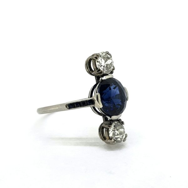 Sapphire and Diamond Three Stone Ring; central oval facetted sapphire flanked top and bottom by a brilliant-cut diamond, mounted in platinum