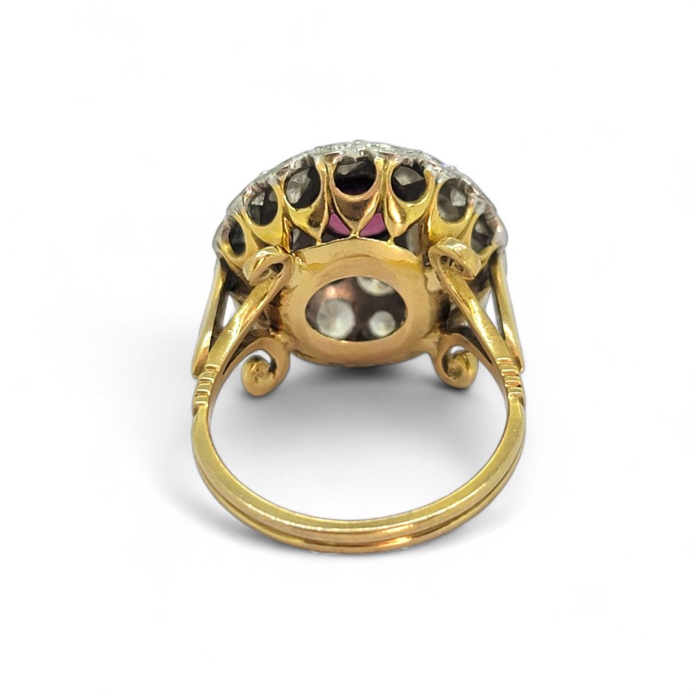Ruby and Diamond Bombe Cluster Ring, central red ruby sits atop a domed bombe cluster of sparkling diamonds in white gold to an 18ct yellow gold shank with decorative scrolled shoulders