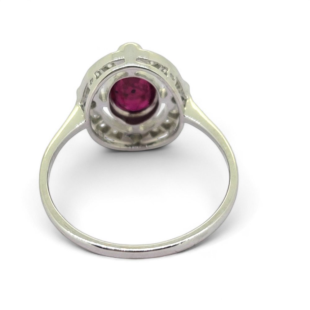Ruby and Diamond Halo Cluster Engagement Ring, 0.70ct oval red ruby surrounded by fixed halo of diamonds with larger diamonds at the four compass points in 18ct white gold