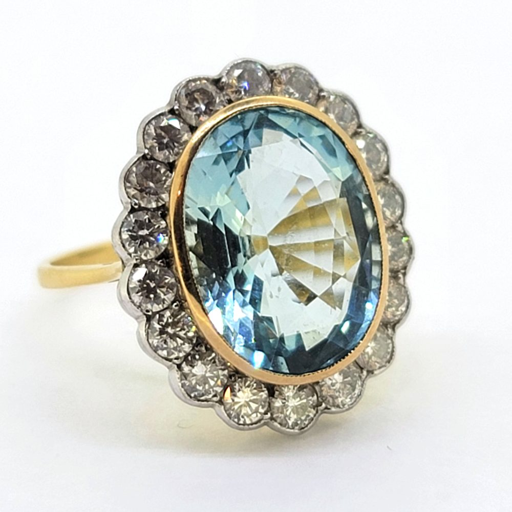 7.98ct Oval Aquamarine and Diamond Cluster Ring, 7.98ct oval-shaped aquamarine bezel set in yellow gold and surrounded by 1.55cts brilliant-cut diamonds in white gold to an 18ct yellow gold band