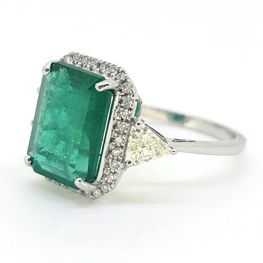3.85ct Emerald and Diamond Cluster Ring with Trillion Diamond Sides, 3.85ct emerald-cut emerald within brilliant-cut diamond border with trillion-cut diamond to each side in 18ct white gold