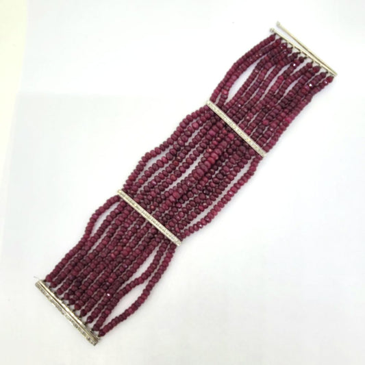 Multi Strand Ruby Bead and Diamond Bracelet, 150 carats, wide bracelet composed of ten strands of ruby beads secured with sections of diamond-set white gold bars